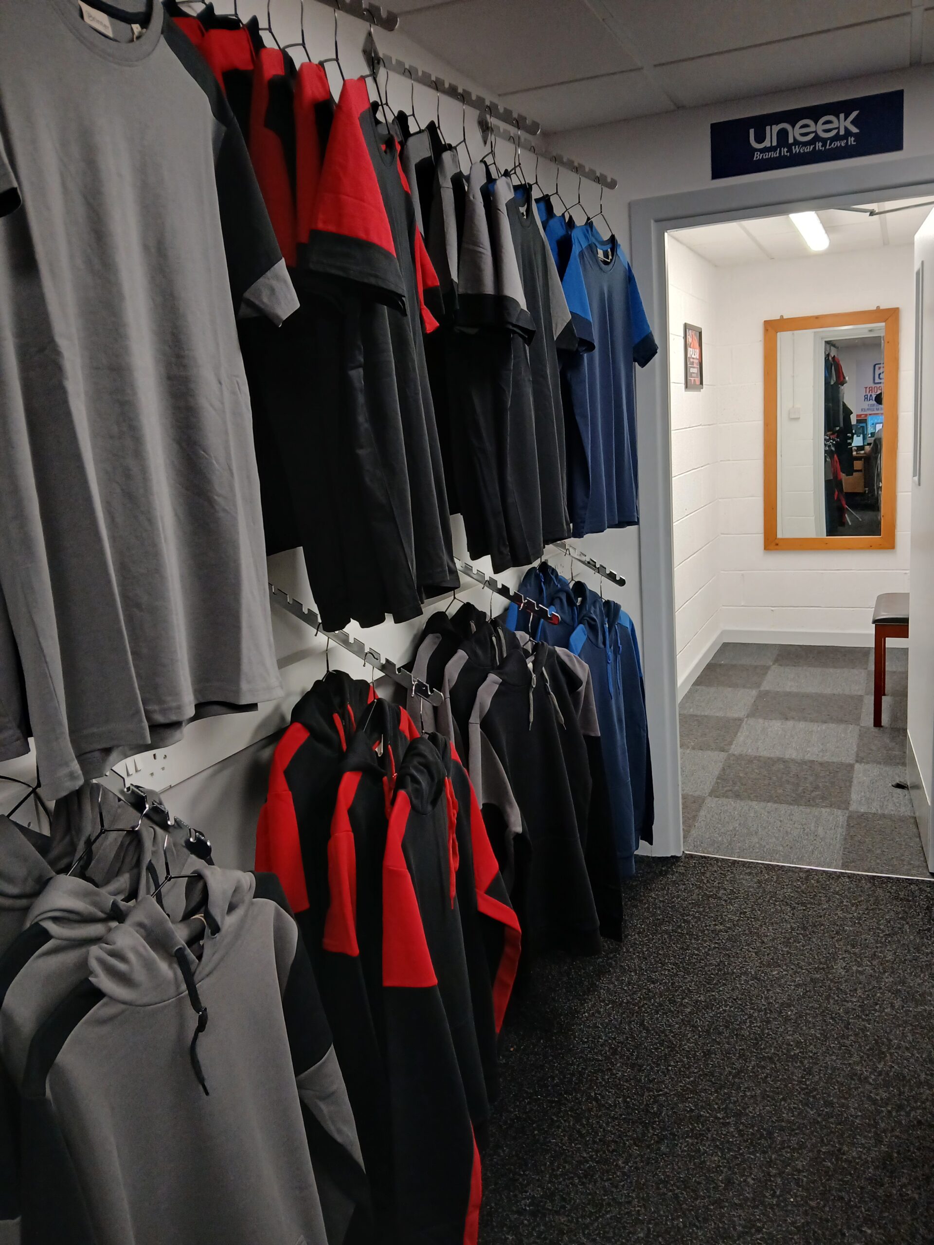 Workwear displayed beside the fitting room at the Southport Workwear showroom