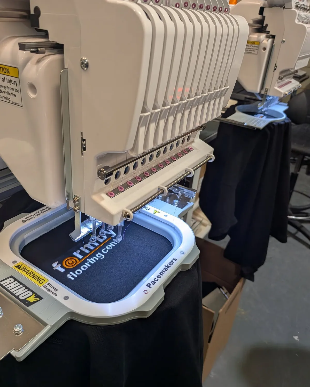 Commercial embroidery machines applying a customer logo to workwear at Southport Workwear
